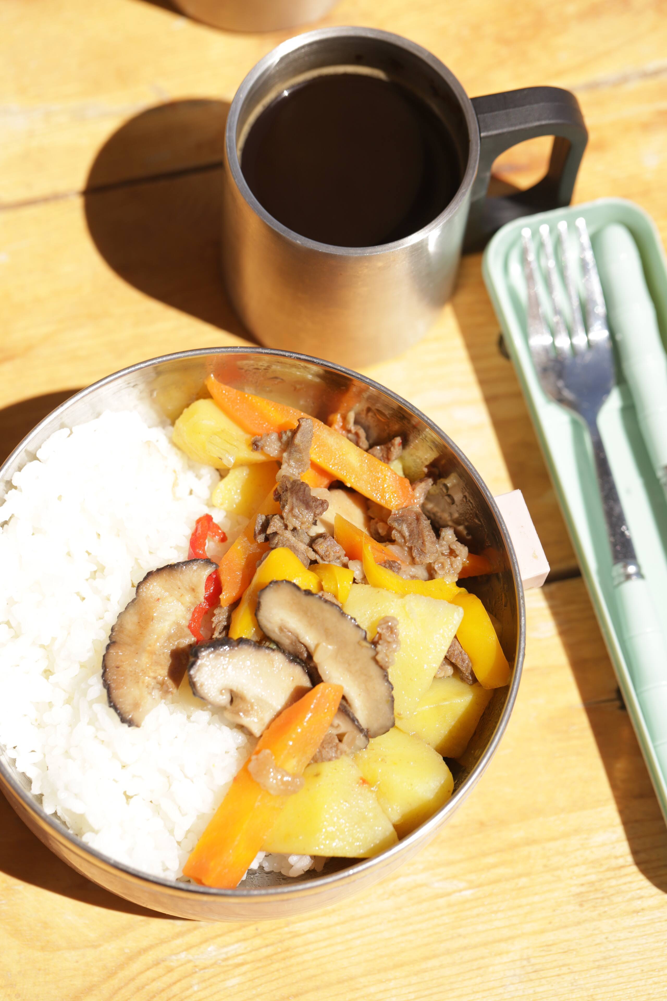 Traditional Mongolian meal with rice vegetables and meat served in camp